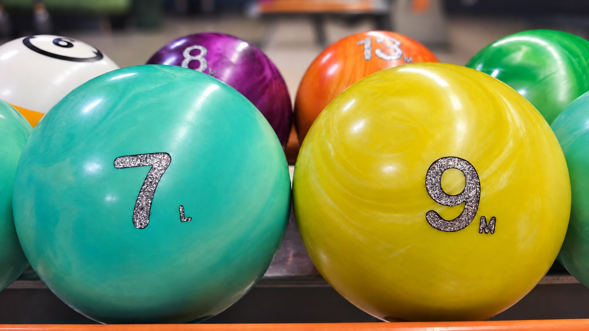 Bowling kugle na povratniku s vidljivom oznakom težine i veličine rupa